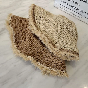 Detailed texture of hand-woven straw hats with frayed edges in beige and brown tones