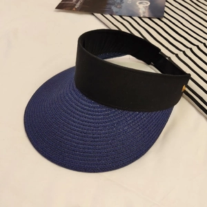 Close-up of blue straw sun visor with black fabric band and golden rivet detail