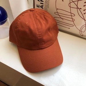 Dettaglio del cappellino da baseball rosso ruggine in twill di cotone con visiera curva