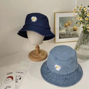 Detail van denim vissershoeden in donker- en lichtblauwe wassing met geborduurde madeliefjes