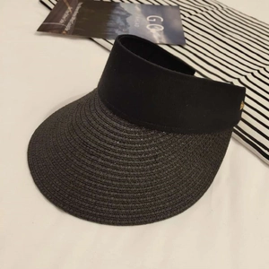 Detail view of woven texture and gold triangle buckle on black sun visor hat