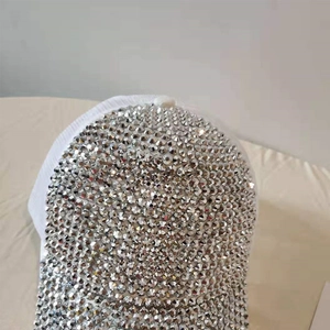 Close-up of sparkling silver rhinestones on a white mesh breathable baseball cap