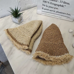 Close-up of hand-woven straw hats featuring frayed edges and detailed knit texture