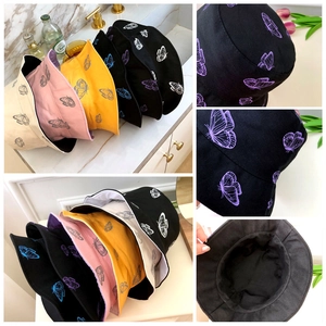 Detail view of double-sided bucket hats with butterfly prints in multiple colors and textures