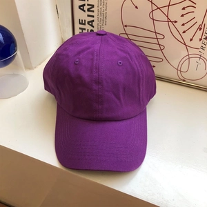 Dettaglio di un cappellino da baseball in cotone viola con occhielli ricamati e visiera cucita