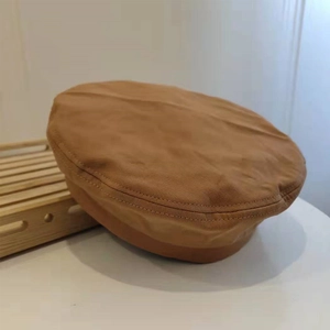 Detail view of caramel cotton beret showing reinforced stitching and twill fabric texture