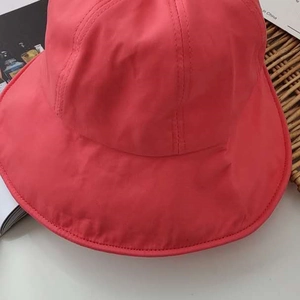 Detail of coral pink foldable sun hat showing water-resistant fabric and fine stitching