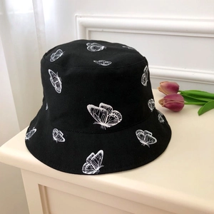 Detailed close-up of white butterfly embroidery on a black canvas fisherman hat