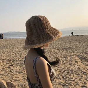 Handmade woven brown straw sun hat with frayed brim for beach vacations