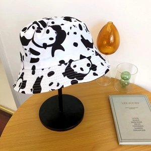 Détail du bord surpiqué et du motif vache sur le chapeau bob en toile de coton