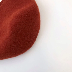 Close-up of rust-red wool felt bucket hat texture with soft high-quality fabric detail