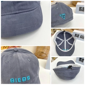 Detail of gray-blue short brim baseball cap with BIEBS embroidery and adjustable buckle