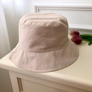 Detail shot of a minimalist beige cotton bucket hat with reinforced brim stitching
