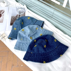 Three casual denim bucket hats in various blue shades with yellow smiley face embroidery