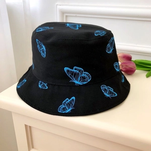 Detailed texture of black bucket hat with blue butterfly pattern for women's sun protection