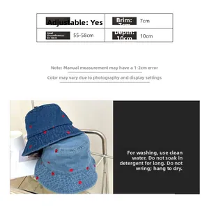 Detail view of denim bucket hat sizing chart and red heart embroidery on blue fabric