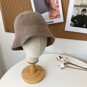 Detail view of a beige wool bucket hat on a model stand with vintage autumn decor