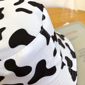 Gros plan du chapeau bob à motif vache montrant la texture du tissu et les coutures