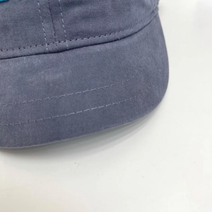 Close-up of double-stitched brim on gray-blue cotton short brim baseball cap