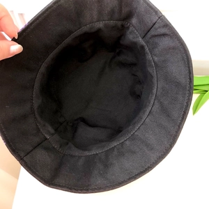 Detail view of the durable cotton canvas lining and stitching of the black bucket hat