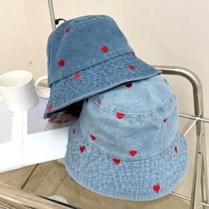 Detail of red heart embroidery on blue denim bucket hats for a vintage style