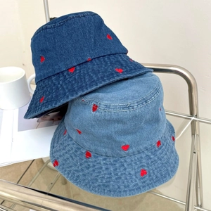 Detail of red heart embroidery on denim bucket hats in dark and light blue wash