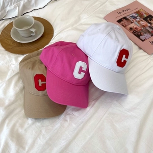 Three cotton baseball caps with embroidered C letter in white, pink and brown colors