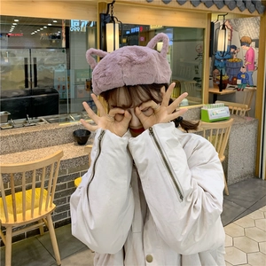 Detail of cute purple plush cat ear hat paired with cream jacket and sleeve zipper detail