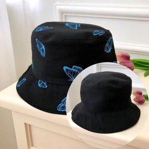 Detail of black double-sided bucket hat with blue butterfly prints and high-quality canvas fabric