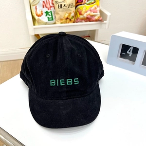 Close-up of black corduroy baseball cap with green BIEBS embroidery and vintage short brim