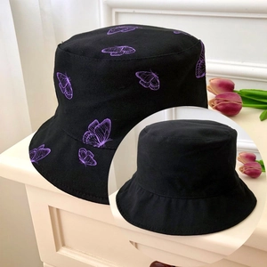 Detail of black cotton bucket hat with purple butterfly embroidery and plain black reverse