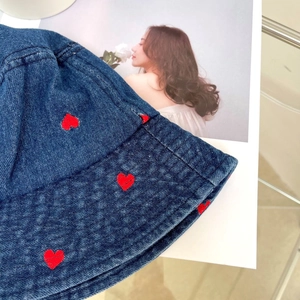 Detail of red heart embroidery on blue denim bucket hat with high-quality stitching