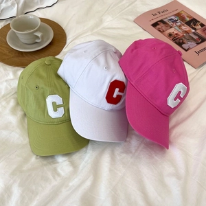 Detailed embroidery of capital C on casual baseball caps in green, white, and rose red