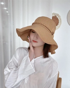 Detail of a brown striped wide-brim sun hat with woven rope decor for women
