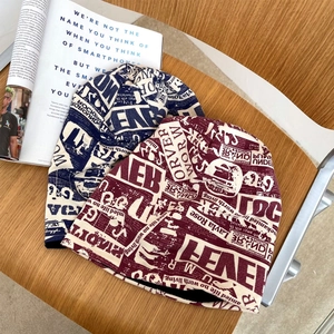Berretti in maglia con stampa graffiti blu navy e bordeaux su tavolo in legno