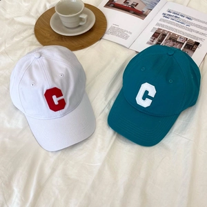 Detailed embroidery of letter C on white and teal cotton baseball caps with air vents