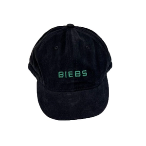 Minimalist black cotton baseball cap with green BIEBS embroidery in a street style look