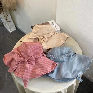Three elegant wide brim sun hats with bows in pink, beige, and blue colors