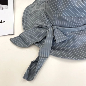 Close-up of blue and white striped sun hat fabric with large side bow decoration