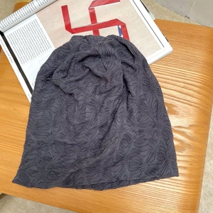 Makro-Detail einer dunkelgrauen Beanie-Mütze mit strukturierter Faltenstrick-Optik