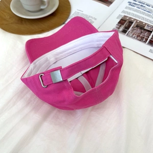 Detail view of pink cotton baseball cap with adjustable silver metal buckle on back