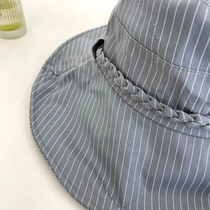 Detail shot of striped sun hat with braided decorative band and high texture canvas fabric
