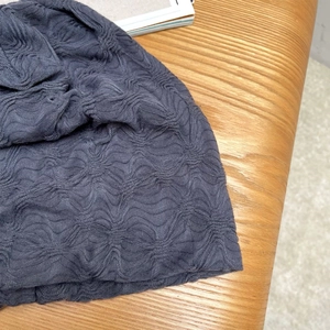 Detailansicht der grauen Strickmütze mit einzigartiger 3D-Blasen-Plissee-Stoffstruktur