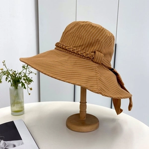 Detail of yellow striped sun hat showing breathable cotton texture and bow ribbon tie