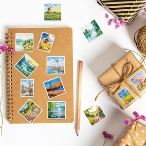 Flat lay view of impressionist landscape art stickers on a vintage notebook with dried flowers