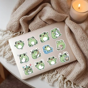 Detail van schattige waterdichte kikkerstickers op een zilveren laptopoppervlak