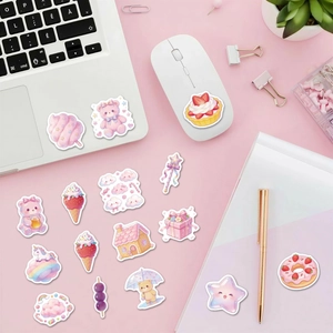 Flat lay of cute pink dessert stickers on laptop and notebook for stationery decoration