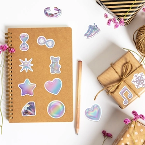 Gros plan d'autocollants Y2K holographiques sur boîte cadeau et carnet, style DIY