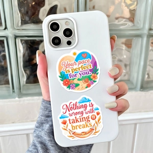 Detailed view of positive quote stickers on a white phone case with floral illustrations