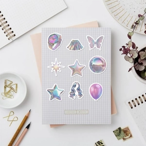 Détail d'autocollants Y2K holographiques avec motifs papillon et étoile sur un bureau